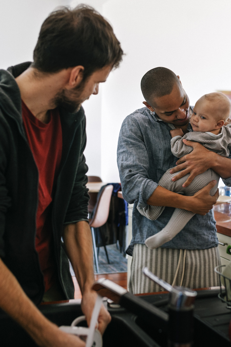 Person Holding A Baby In Kitchen